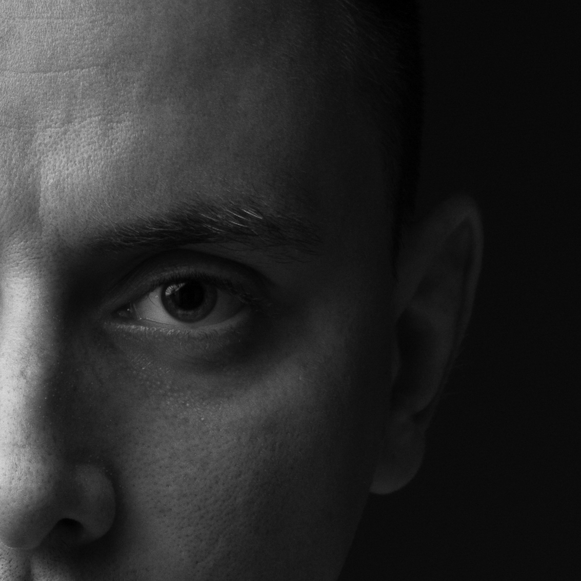 Close-up portrait of Urosh Nou in shadow